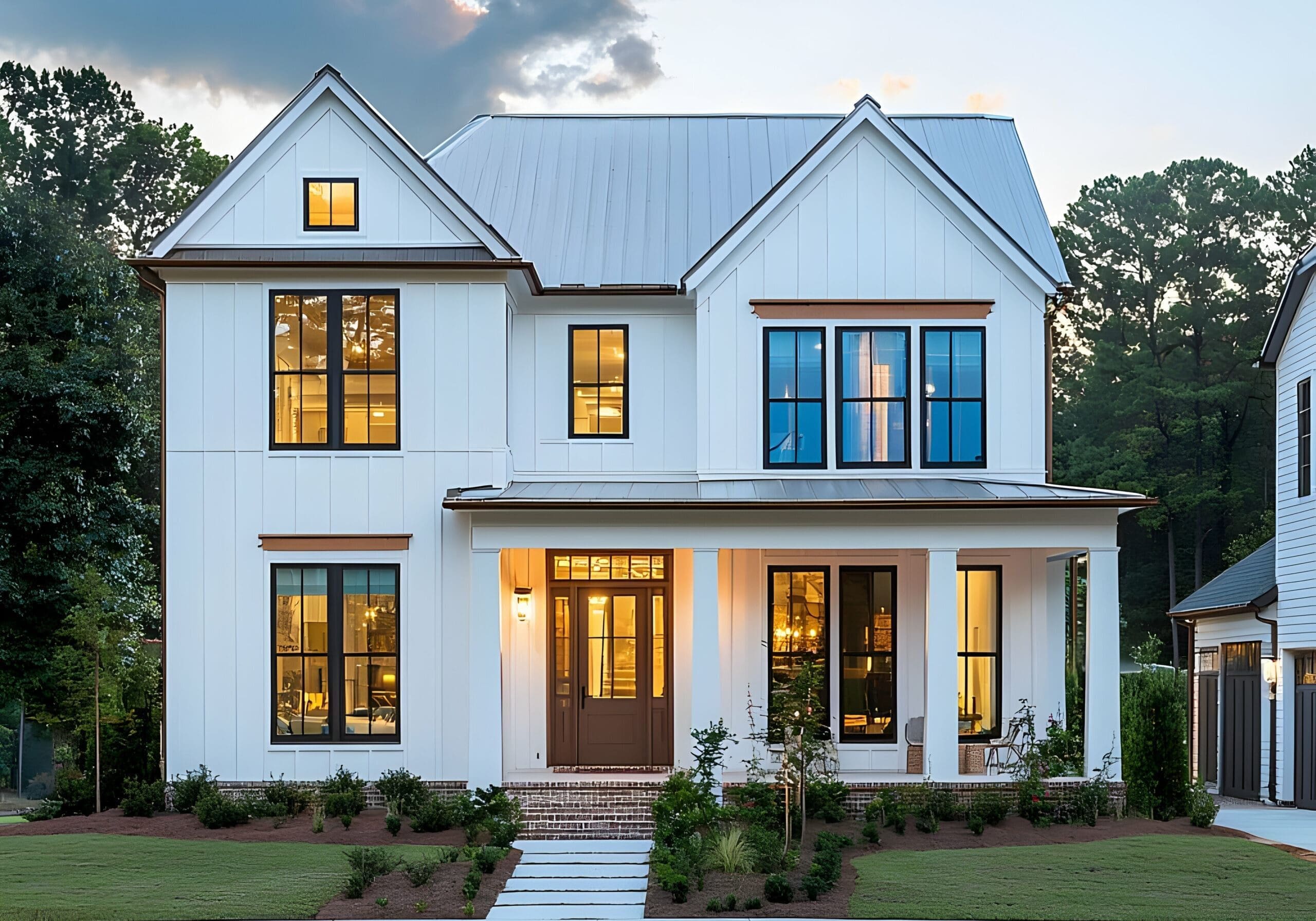 Modern white farmhouse in Loganville, Georgia, with large black-trim windows, glass-paneled front door, porch, and manicured lawn.