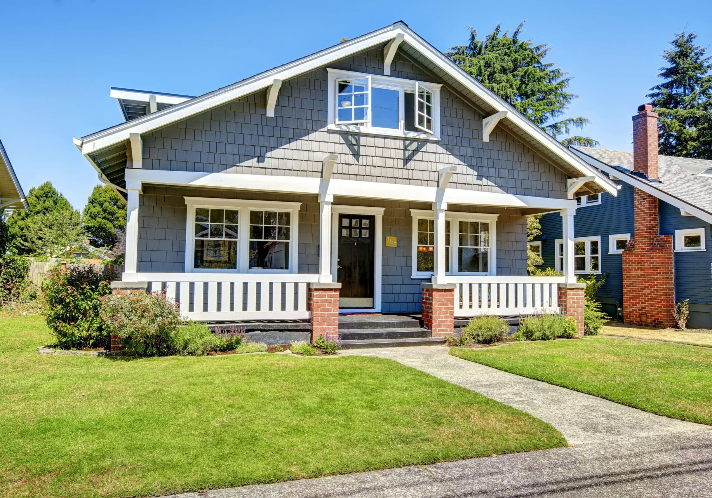 Gray craftsman bungalow with white trim and multiple windows in Alpharetta, Georgia, featuring a covered front porch.